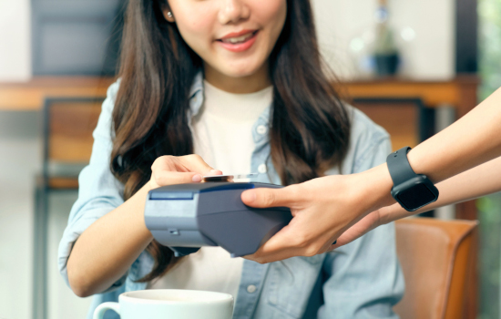 Young asian woman holding credit card for paying contactless at coffee shop, cafe background, Small business financial and contactless payment concept, close up